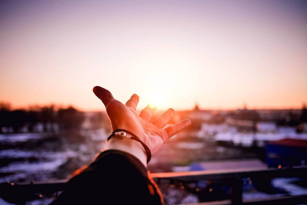 Main tendue vers le soleil et ses rayons synonymes de vitamine D